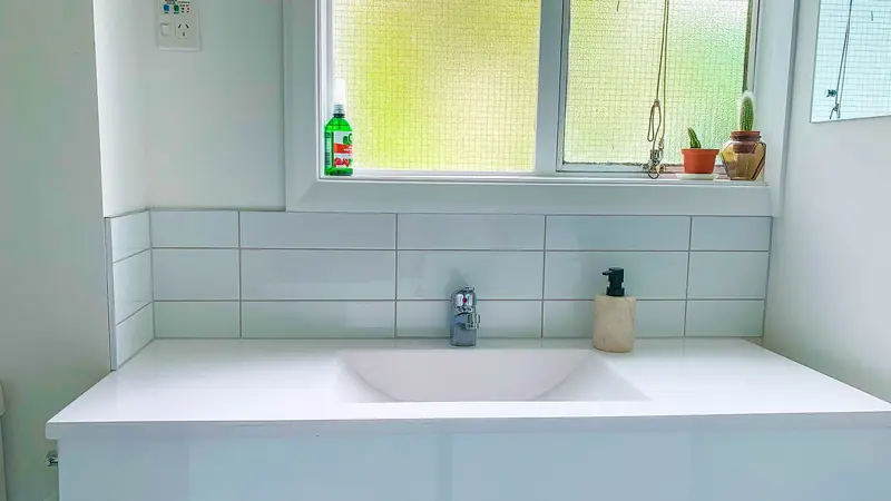 Geflieste Spritzschutzwand über einer Ablage